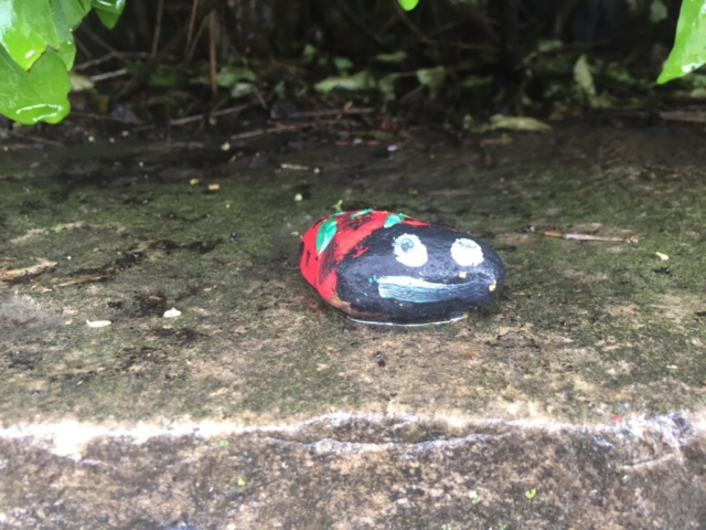Small rock painted to look like ladybug