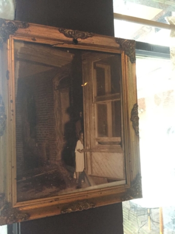 Framed photo of child peering around a corner